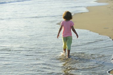 Yaz tatili. Denizde oynayan bir çocuk. Çocuklar sahilde eğleniyor..