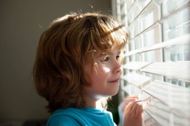 Karantina konsepti. Koru kendini. Evde tek başına kal. COVID-19 tecrit. Pencereden bakan çocuk. Koronavirüs salgını.