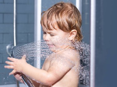 Çocuk banyo yaparken eğleniyor. Komik, mutlu bebek küvette su ve köpükle yıkanır. Çocuk hijyeni..