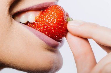 Kırmızı çilek yiyen dişi dudaklar. Seksi dudaklı bir kadın kırmızı çilek meyvesi yiyor, yakın plan..