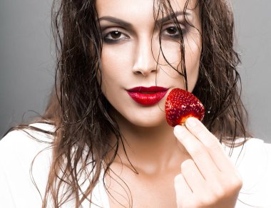 Seksi kırmızı dudaklı, güzel yüzlü, ıslak saçlı, çilekli meyveli seksi bir kadın..