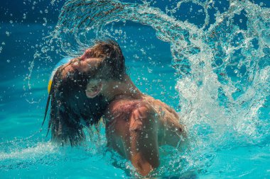 Islak saçlarından ve sakalından su sıçrayan genç adam yazın yüzme havuzunda eğleniyor..