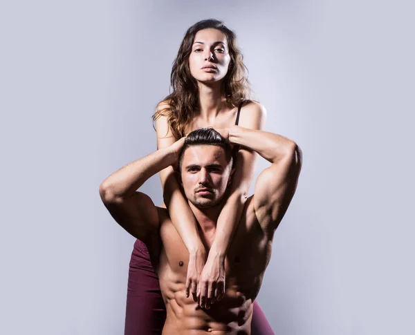 Sexy pareja con torso desnudo muscular y cuerpo atlético en estudio sobre fondo gris. — Foto de Stock