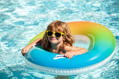 Aquapark Çocukları yaz tatilindeki çocuk. Havuzdaki çocuk. Şişirilebilir lastik çemberdeki mutlu çocuk..