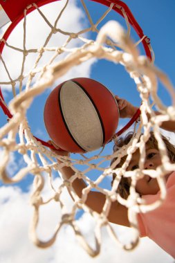 Basketbol oynayan çocuk. Tepeden tırnağa uçan top görüntüsü, çocuk basketbol oynuyor..