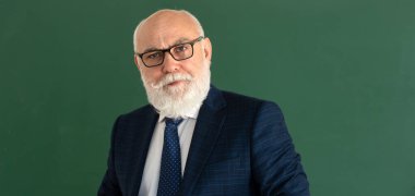 Yaşlı öğretmen. Zarif takım elbiseli komik profesör ya da bilim adamı. Boşluğu karatahtaya, tahtaya, panoya kopyala.