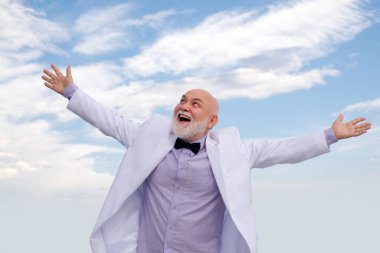 İşçilik başarısı. Yaşlı olgun adam. Beyaz takım elbiseli başarılı erkek işadamı eğleniyor..