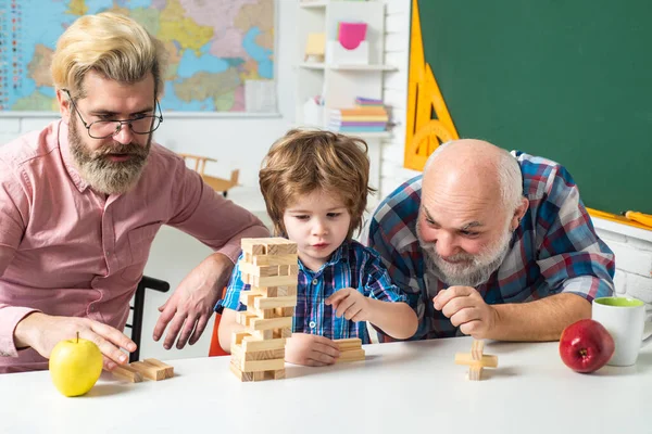 Jenga game at home. Happy generational muti three generation men family portrait. Man in different ages.