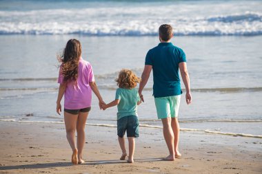 Baba, anne ve çocuk Bora Bora 'da gün batımında yaz plajında. Arkadaş canlısı aile kavramı. Aile seyahati, tatil konsepti.