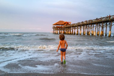 Denizde oynayan mutlu çocuk. Yaz tatili ve tatil konsepti.
