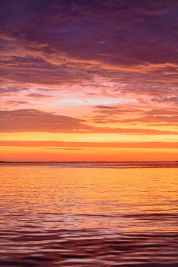 Dramatik bir gökyüzü. Okyanus suyunun üzerinde gün doğumu güneşi. Doğal gün batımı.