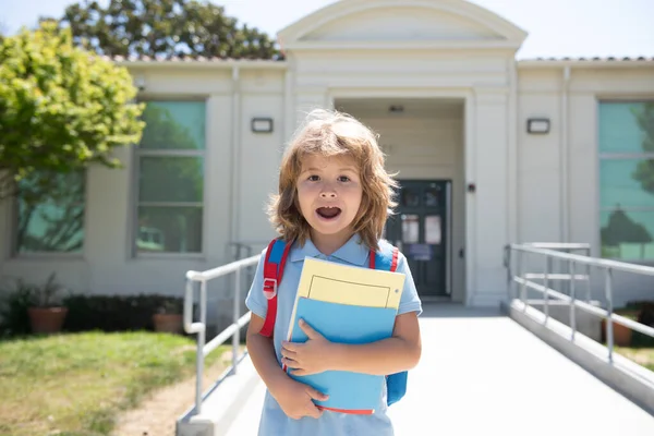 Elève de l'école primaire en route pour étudier. Première année avec sac d'école. Début des leçons. Garçon à l'extérieur près du bâtiment scolaire. — Photo