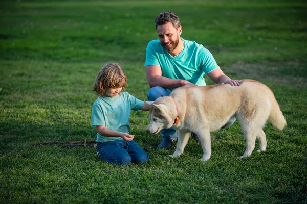 Baba oğul ve evcil köpek birlikte dışarıda vakit geçiriyorlar.. — Stok fotoğraf