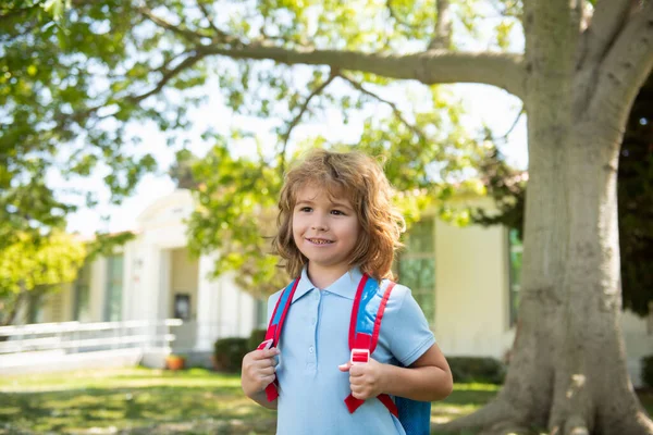 Enfant avec des sacs à dos debout dans le parc près de l'école. Elèves avec livres et sacs à dos à l'extérieur. Concept d'éducation des enfants. — Photo