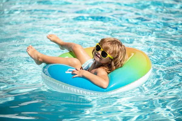 Zomervakantie. Zomer kinder weekend. Een jongen in een zwembad. Grappige jongen op opblaasbare rubberen cirkel. — Stockfoto