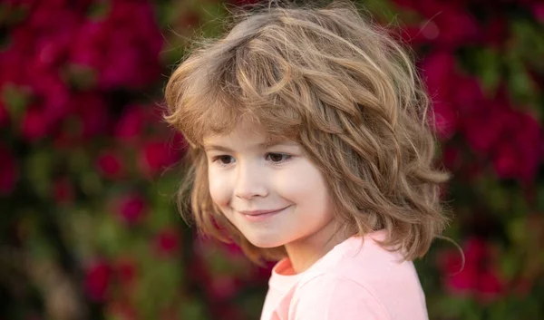 Retrato infantil ao ar livre. Miúdo bonito com rosto sorridente. — Fotografia de Stock