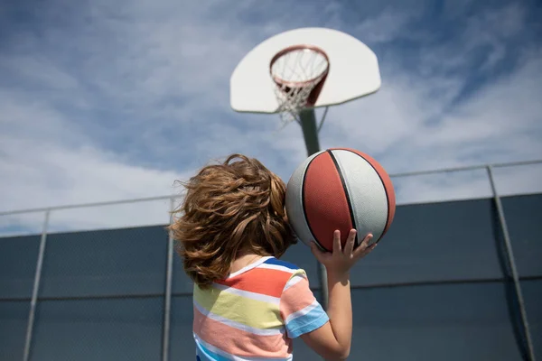 Een kleine jongen die basketbalt met basketbal. Basketbal kinderen school. — Stockfoto