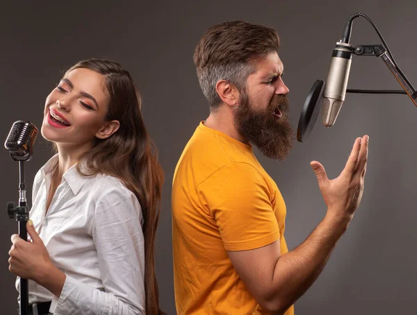 Šťastný pár v nahrávacím studiu. Hudební zpěv. Zpěvačka zpívající píseň s mikrofonem. — Stock fotografie