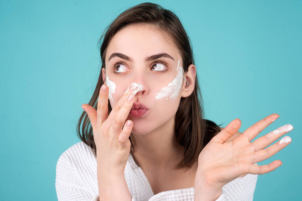 Beautiful girl model apply a cleansing mask on face.