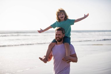Babası onu omuzlarında taşıyan küçük bir çocuk. Baba ve çocuk bahar gününün tadını çıkarıyorlar. Erkekler üretimi kavramı.