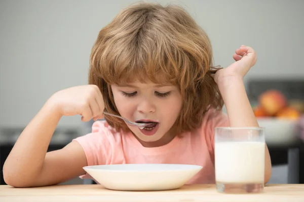 Grappig kind met een bord soep. Kinderdiner. Kind van de kleuterschool geniet van ontbijt in de ochtend, lepel vasthouden. Gezonde voeding voor kinderen. — Stockfoto