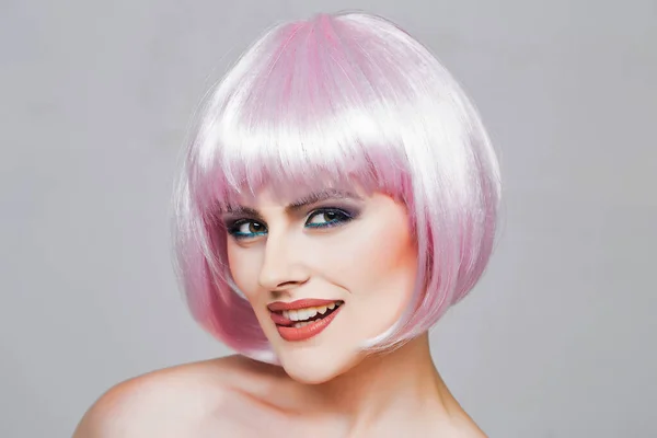 Sexy glamour meisje of vrouw met modieuze make-up op mooie glimlachende gezicht en korte kapsel of roze pruik. — Stockfoto