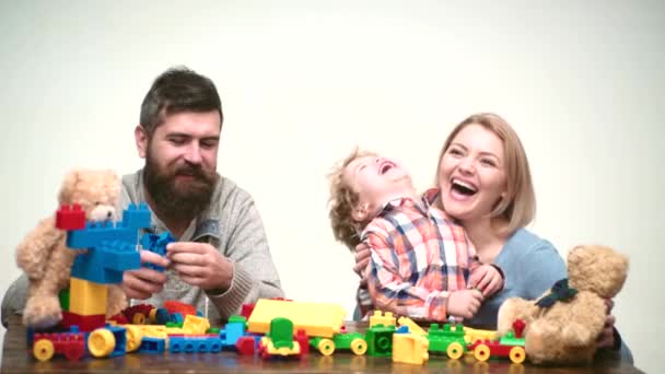 Батьківство. Сім'я грає з конструктором. Дитина з іграшковою цеглою. Щаслива дитина грає з матір'ю та батьком. Різнокольорові блоки . — стокове відео
