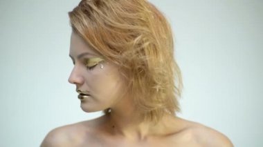 Altın yüz sanatı. Güzellik kozmetiği. Altın makyajlı kadın. Moda sanatı teni. Altın kadın portresi. Yakın plan..