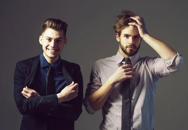 Guapos jóvenes hombres de negocios amigos en chaqueta, camisa y corbata tiene el pelo de moda y la cara seria y sonriente sobre fondo gris. Elegante sexy hombres o chicos en el estudio —  Fotos de Stock