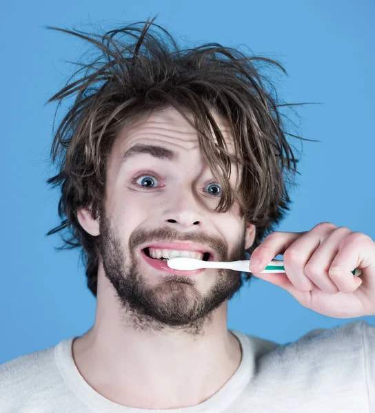 Ένας άντρας με εσώρουχα βουρτσίζει δόντια. Πρωινή μπουγάδα, ξύπνημα, καθημερινή ζωή. Υγιεινή, λεύκανση δοντιών. Στοματολογία και οδοντιατρική περίθαλψη. Χαρούμενος πρωινός άντρας σε μπλε φόντο. — Φωτογραφία Αρχείου