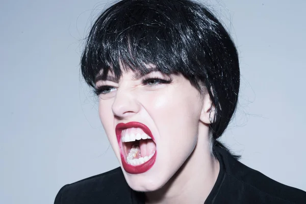 Woman scream close up. Girl with make up screaming on grey background. Angry woman. Girl on scandalous shouting face.