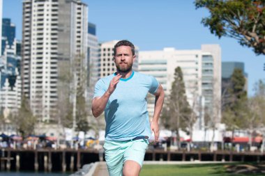 Şehir parkında koşan sağlıklı bir koşucu. Spor ve sağlıklı yaşam tarzı.