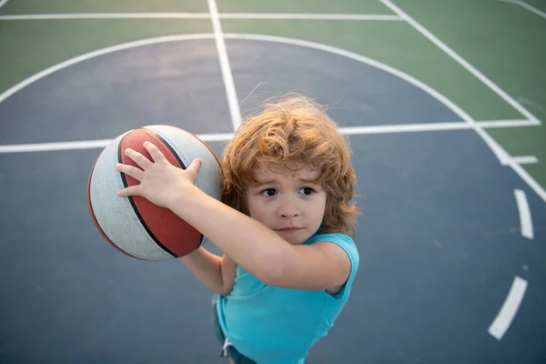 Estilo de vida ativo das crianças. Pouco caucasiano esportes garoto jogando basquete segurando bola com rosto feliz. — Fotografia de Stock