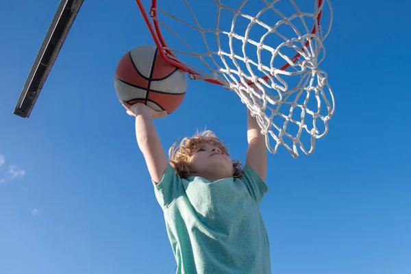Närbild porträtt av unge pojke basket spelare att göra slam dunk under basketmatch. — Stockfoto