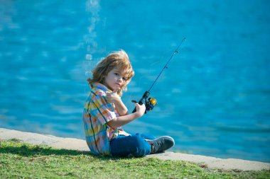 Çocuk balıkçı. Nehirde dönen çocuk. Küçük çocuk balık tutuyor. Rıhtımdaki çubuklu çocuk. Balıkçılık kavramı.