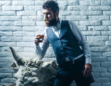 Adam viski içiyor. Degukasyon, tatma. Sakallı adam elinde brendi bardağı tutuyor. Zarif takım elbiseli sakallı bir işadamı ve bir bardak viski. Sommelier 'in pahalı bir içeceği var..