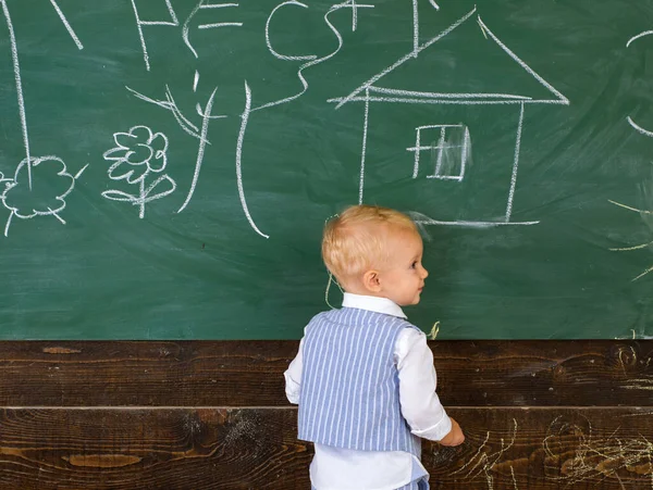 Ragazzo degli alunni che dipinge scarabocchi sulla lavagna dell'aula. Piccolo artista ragazzo creazione immagine il giorno di scuola. — Foto Stock