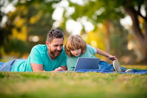 Γιος με τον πατέρα βλέποντας μάθημα σε εξωτερικούς χώρους laptop. — Φωτογραφία Αρχείου