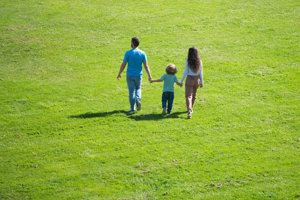 Back view of mother father and child son having fun outdoors at summer park. — Stock Photo, Image