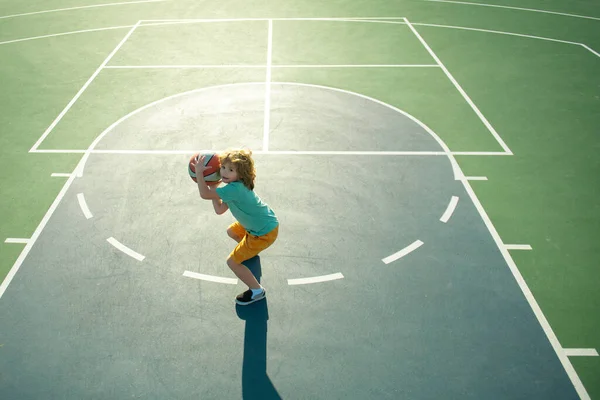Úhel pohledu z vrcholu chlapce chlapce, který hraje basketbal na hřišti. — Stock fotografie