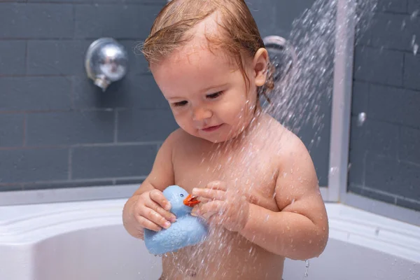 Tvättar bedårande bebis i badrummet. Grabben med tvål suger på håret och badar. Närbild porträtt av leende barn, hälsovård och barn hygien. Barn i dusch. — Stockfoto