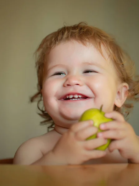 可愛い子がリンゴの実を食べて笑って、背景がぼやけて肖像画。食べる瞬間をお楽しみください。健康的な食べ物と子供の概念。面白い子供の顔をクローズアップ. — ストック写真