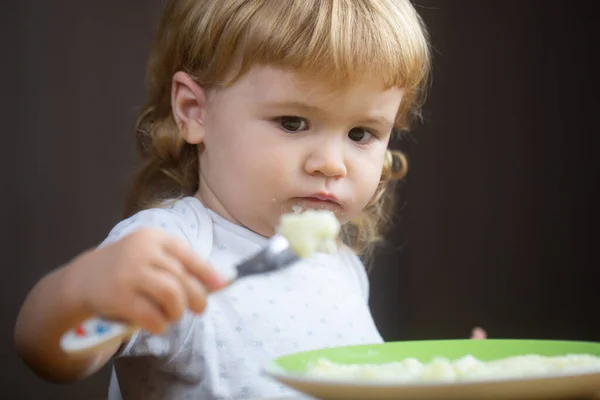 Bebé bonito está sendo alimentado usando colher. — Fotografia de Stock