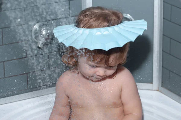 Il bambino in bagno gioca con schiuma. Il bimbo felice divertente si bagna in vasca da bagno con acqua e schiuma. igiene dei bambini. — Foto Stock