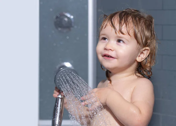 Criança que toma banho abaixo de um chuveiro. Lavando bebê adorável no banheiro. Criança com sabão suds no cabelo tomando banho. Retrato de close-up de criança sorridente, cuidados de saúde e higiene infantil. — Fotografia de Stock