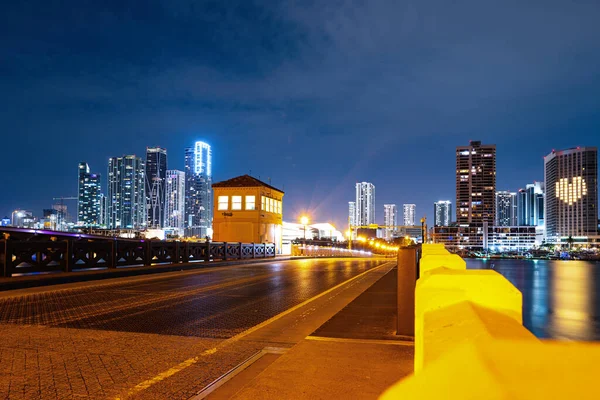 Miami Florida, naplemente panoráma színes megvilágított üzleti és lakóépületek és híd Biscayne Bay. Miami éjszaka a belvárosban. — Stock Fotó