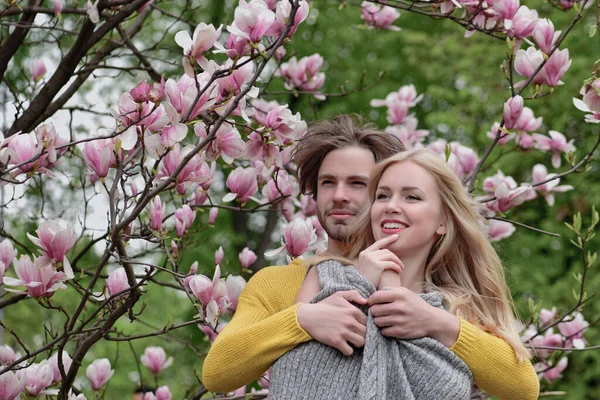Пара влюбленных в весенние цветы магнолии. — стоковое фото