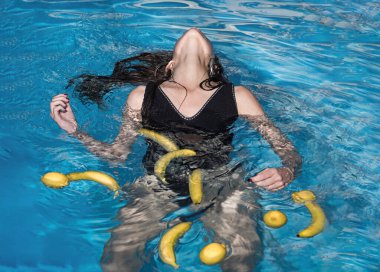 Bilardodaki kız. Lüks tatil. Havuzda muz ve limonlu meyvelerle dinlenen bir kadın. Yaz meyveleri.