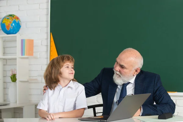 Δάσκαλος και παιδί στην τάξη. Εκπαιδευτική ιδέα. Σχολική ιδέα μάθησης. Δημοτικό σχολείο για αγόρια. Γέρος και νέος — Φωτογραφία Αρχείου