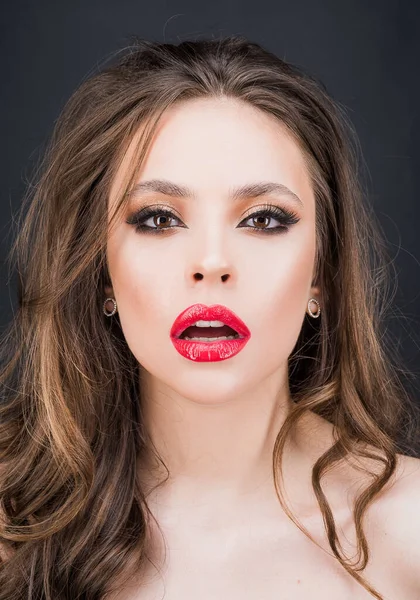 Sensual woman with red lips, black eyes makeup. Closeup face of fashion woman.